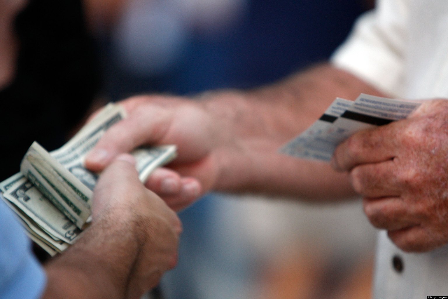 ST PETERSBURG, FL - OCTOBER 22:  A fan holds tickets and another holds money before the Philadelphia Phillies take on the Tampa Bay Rays during game one of the 2008 MLB World Series on October 22, 2008 at Tropicana Field in St. Petersburg, Florida.  (Photo by Jamie Squire/Getty Images)